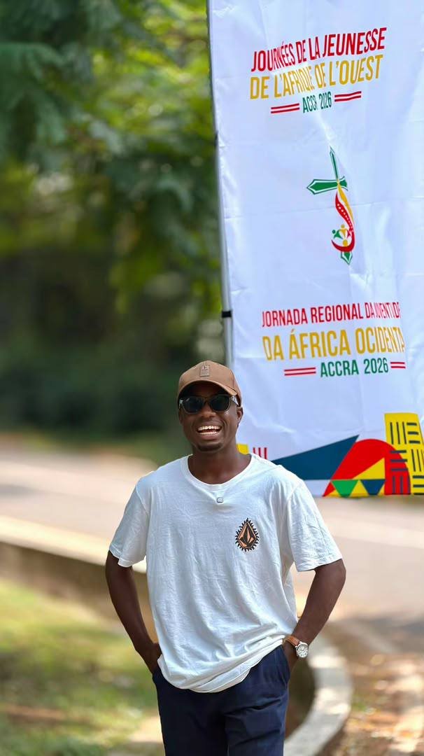 Beside a West Africa Youth Days banner