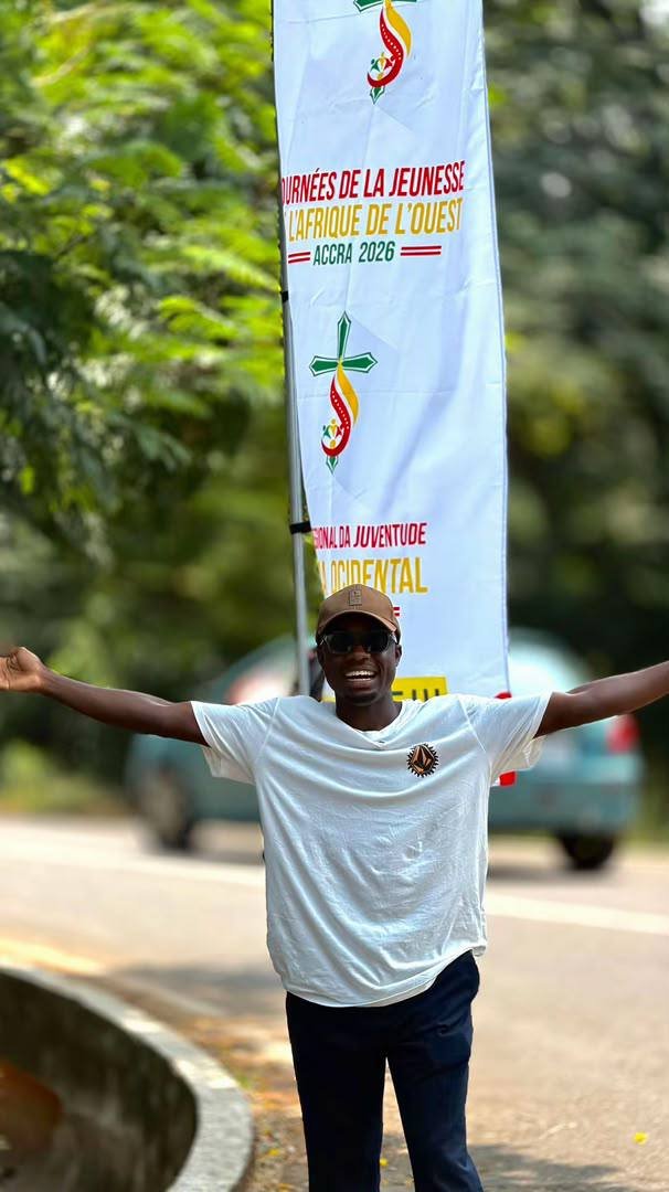 Beside a West Africa Youth Days banner